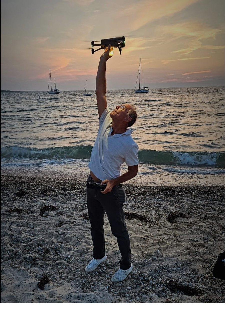 Joe, founder of Rebel Video, flying a drone at sunset on the coast